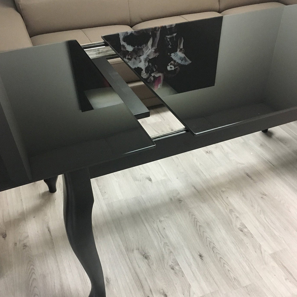 Maxima House Retro dining table with a glass top and curved beech wood legs.