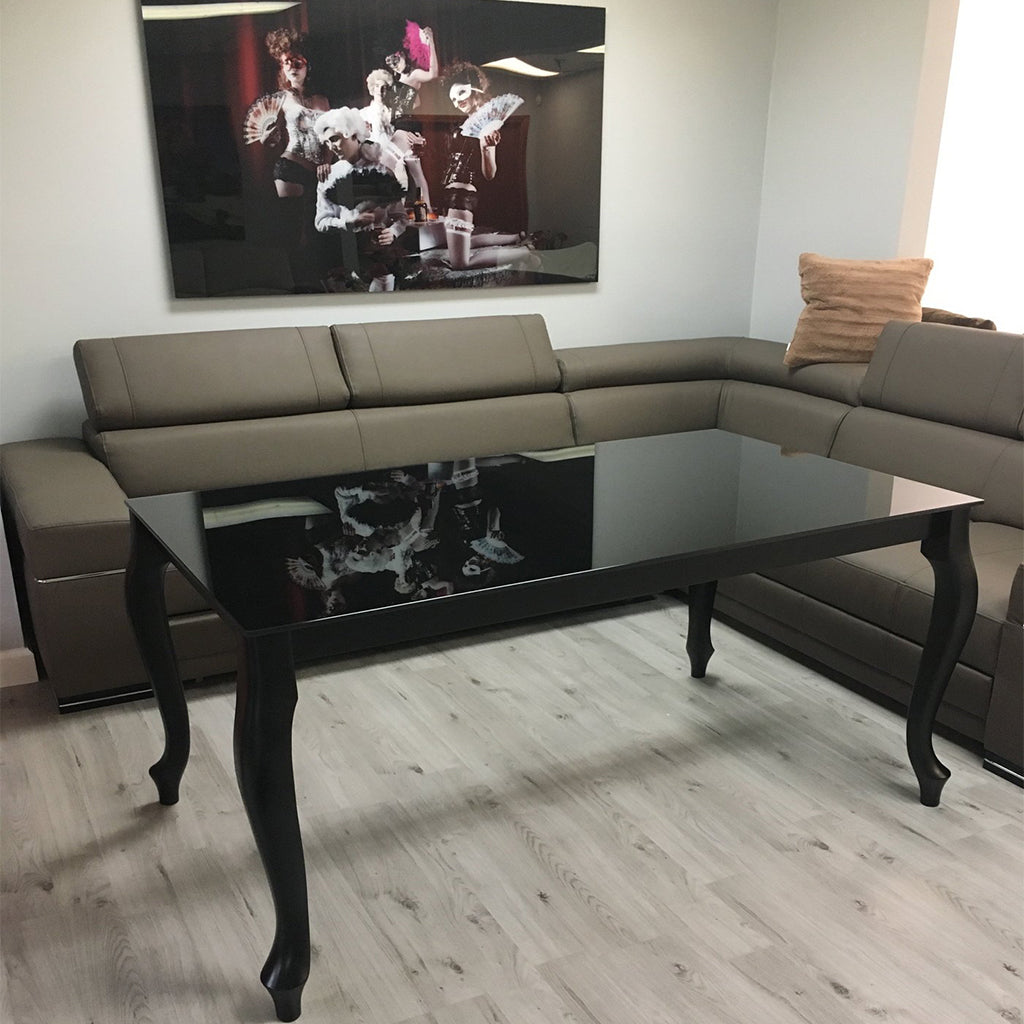 Maxima House Retro dining table with a glass top and curved beech wood legs.