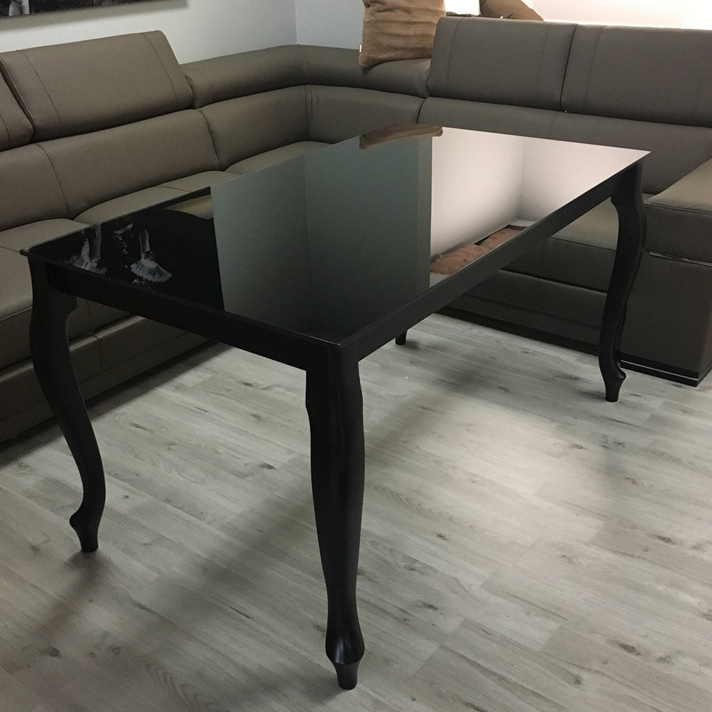 Maxima House Retro dining table with a glass top and curved beech wood legs.