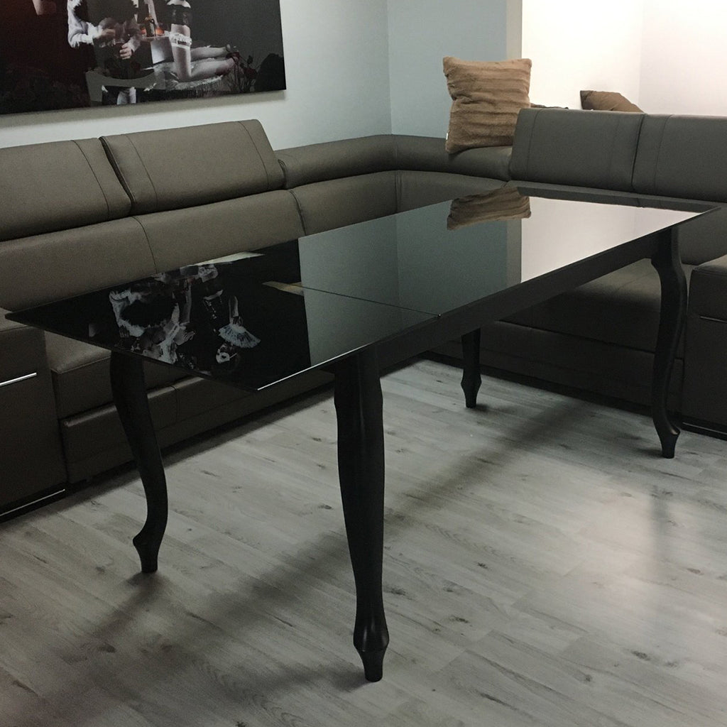 Maxima House Retro dining table with a glass top and curved beech wood legs.